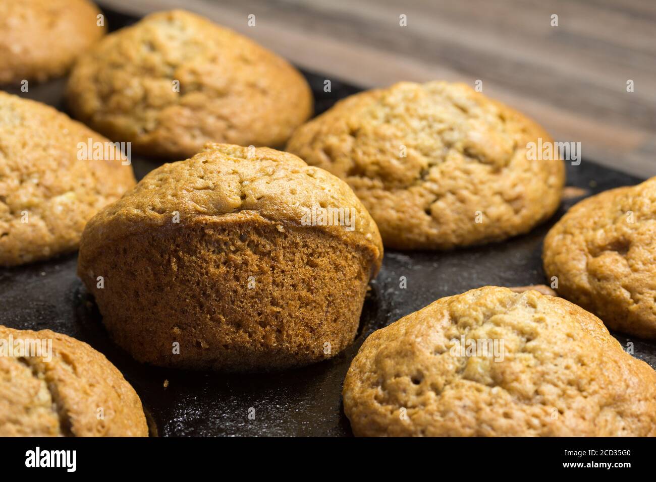 Muffins cuits dans un moule à pâtisserie sur le plan de travail de la cuisine - mise au point sélective Banque D'Images