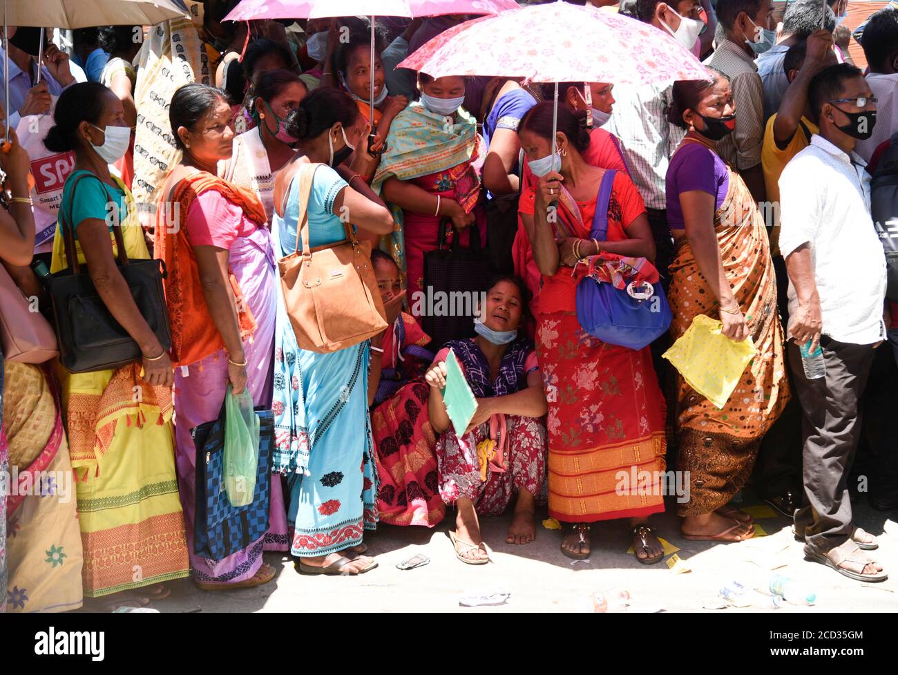 Guwahati, Assam, Inde. 25 août 2020. Les gens flirtent avec les normes de distanciation sociale alors qu'ils se trouvent dans une file d'attente pour s'inscrire aux cartes d'Aadhar, dans le contexte de la pandémie de coronavirus COVID-19 en cours, à Guwahati. Crédit : David Talukdar/ZUMA Wire/Alay Live News Banque D'Images