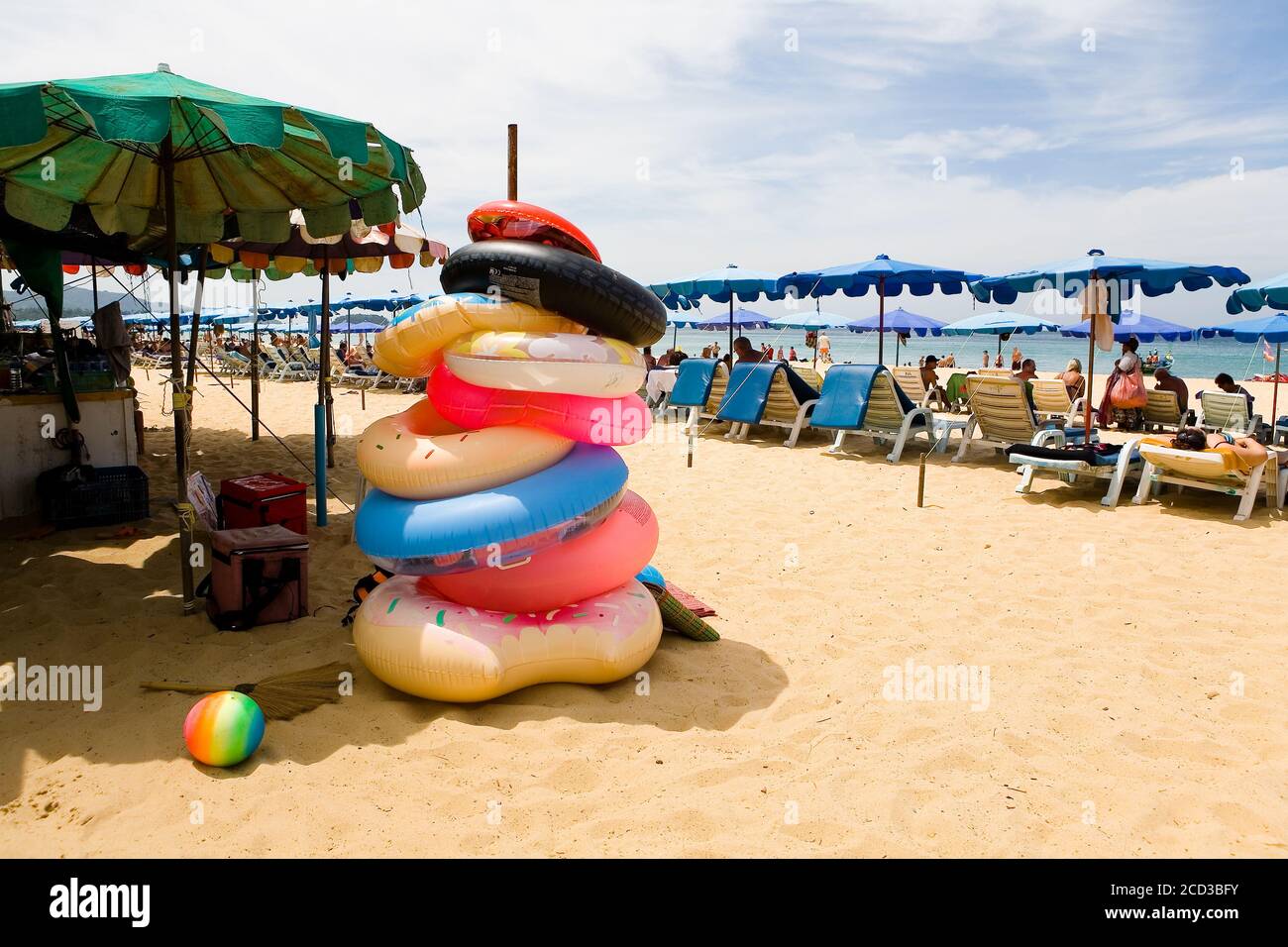 Phuket, Thaïlande, le 20 février 2018 : cercles gonflables et de repos des touristes sur la plage de sable de Karon. Banque D'Images
