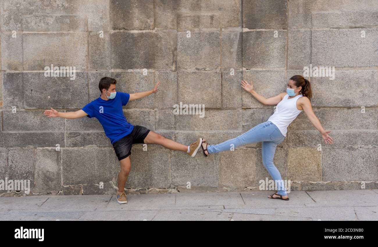 Le nouveau style normal et de message d'accueil. L'homme et la femme qui secouent les coudes ou les pieds en gardant la distance sociale pour éviter la propagation du coronavirus. Éclosion de la COVID-19 et d Banque D'Images