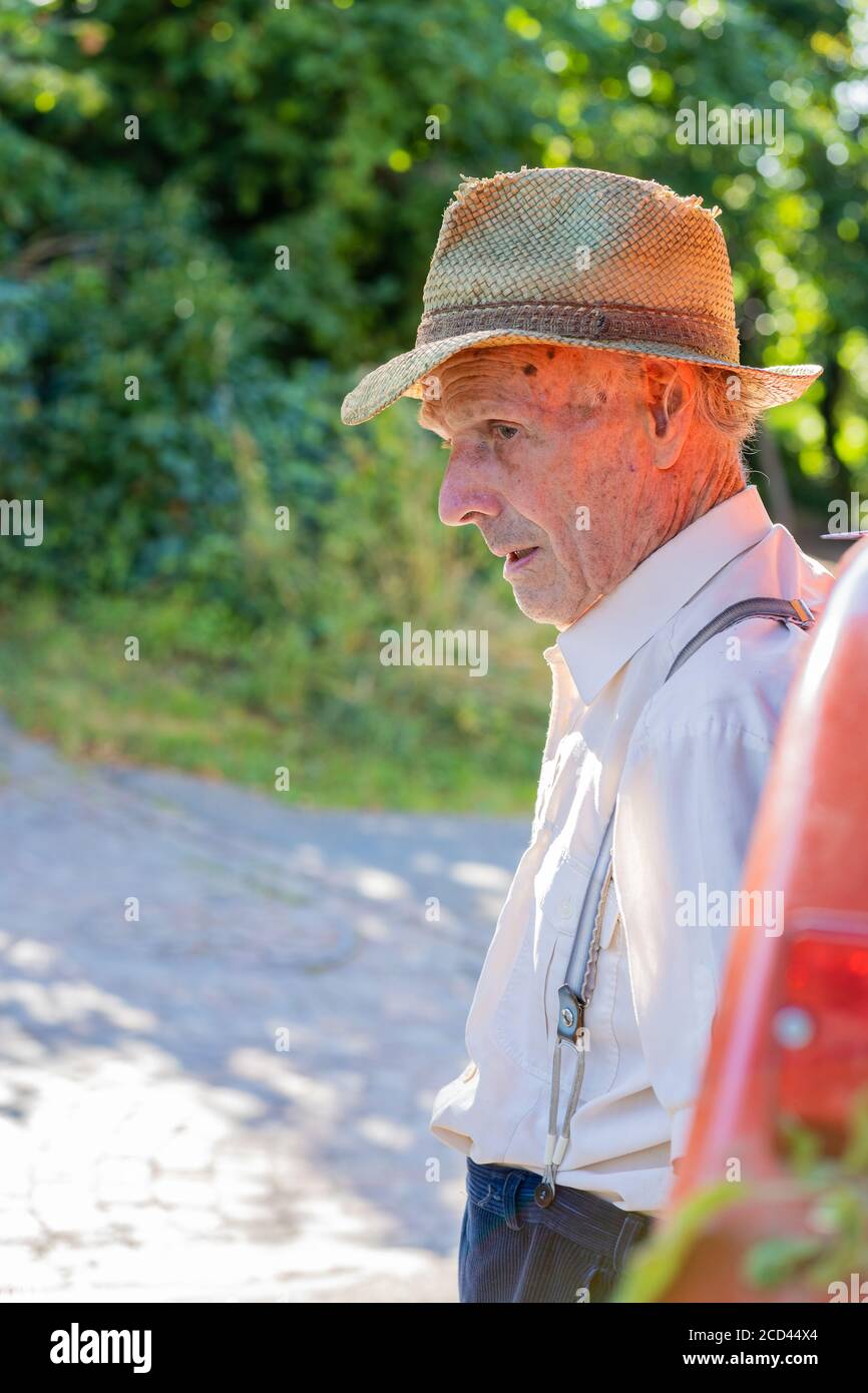 Portrait d'un très vieux fermier avec chapeau de paille pensant à la vie  devant un tracteur rouge. Rétro, gros plan Photo Stock - Alamy
