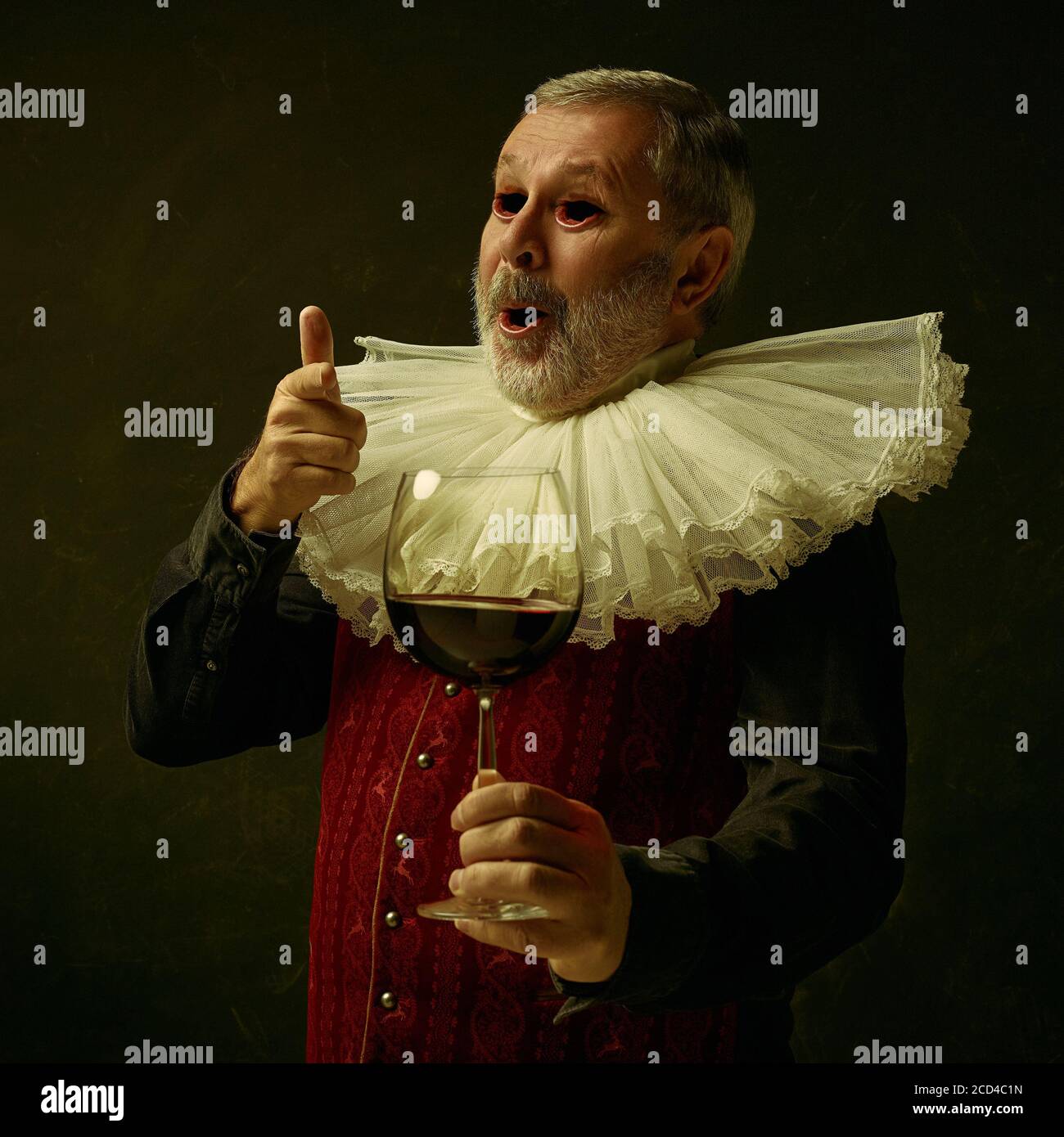 Homme médiéval âgé vêt de vêtements vintage rouges comme un roi ou un prince posant sur un arrière-plan sombre de studio. Concept de comparaison des époques, de la modernité et de la renaissance. Surréaliste regarder avec la bouche au lieu des yeux. Banque D'Images Homme médiéval âgé vêt de vêtements vintage rouges comme un roi ou un prince posant sur un arrière-plan sombre de studio. Concept de comparaison des époques, de la modernité et de la renaissance. Surréaliste regarder avec la bouche au lieu des yeux. Banque D'Images