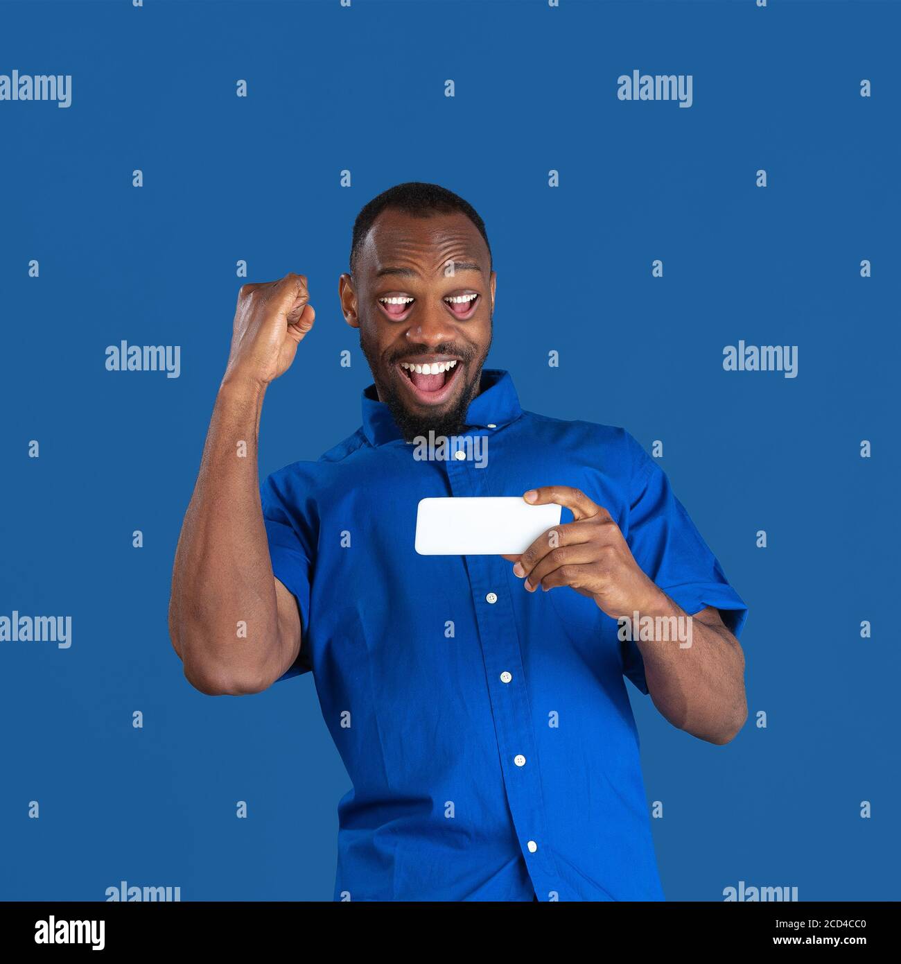 Portrait afro-américain de l'homme isolé sur fond de studio, monochrome. Beau modèle mâle avec la bouche au lieu des yeux. Concept des émotions humaines, expression faciale, ventes, publicité. Collage surréaliste. Banque D'Images