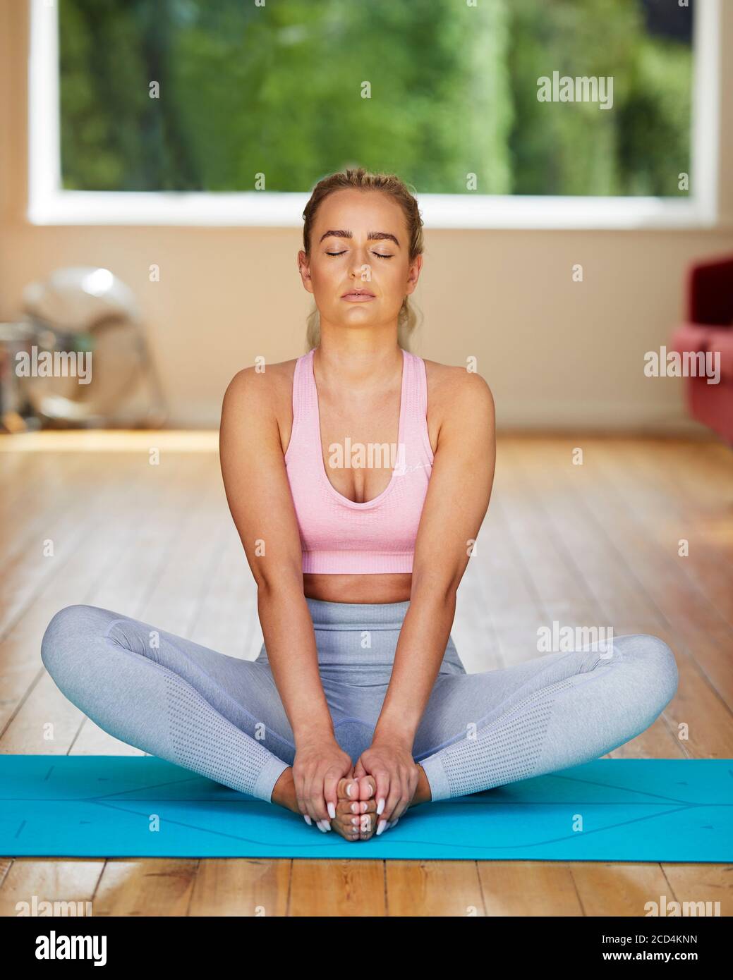 Jolie fille blonde pratiquant le yoga Banque D'Images