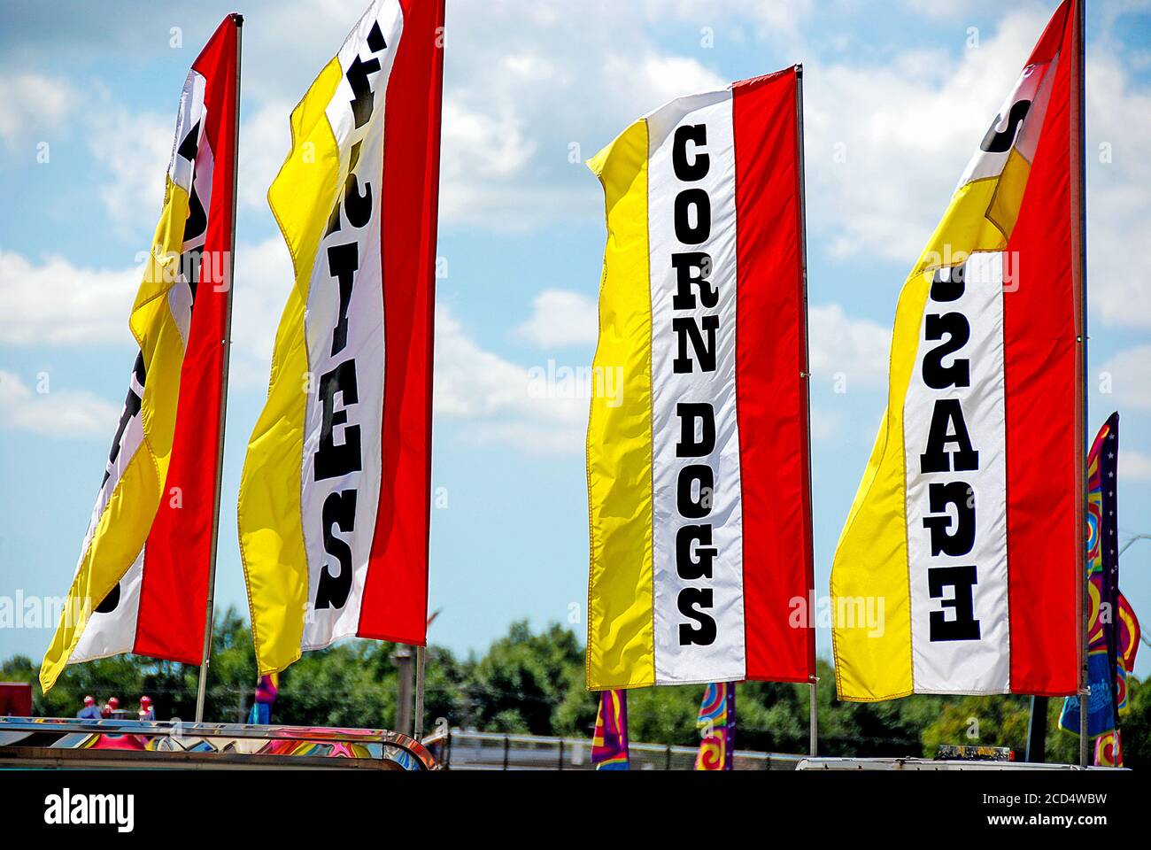 Banderoles jaune et rouge sur les poteaux publicitaires pour la nourriture vente à une foire du comté Banque D'Images