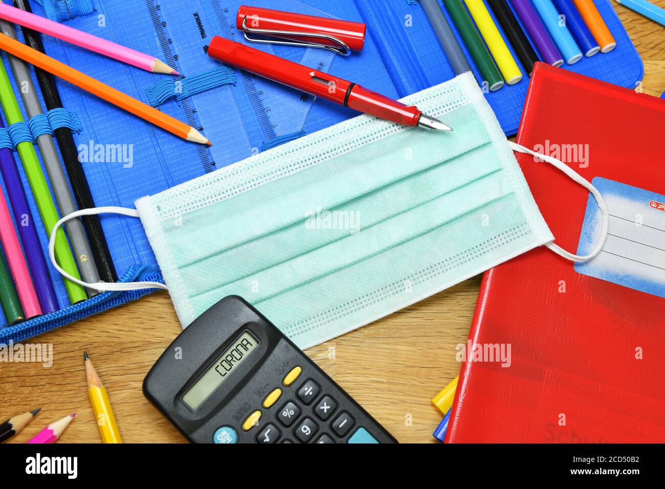 Masque facial Corona et étui à crayons sur le bureau de l'école Banque D'Images