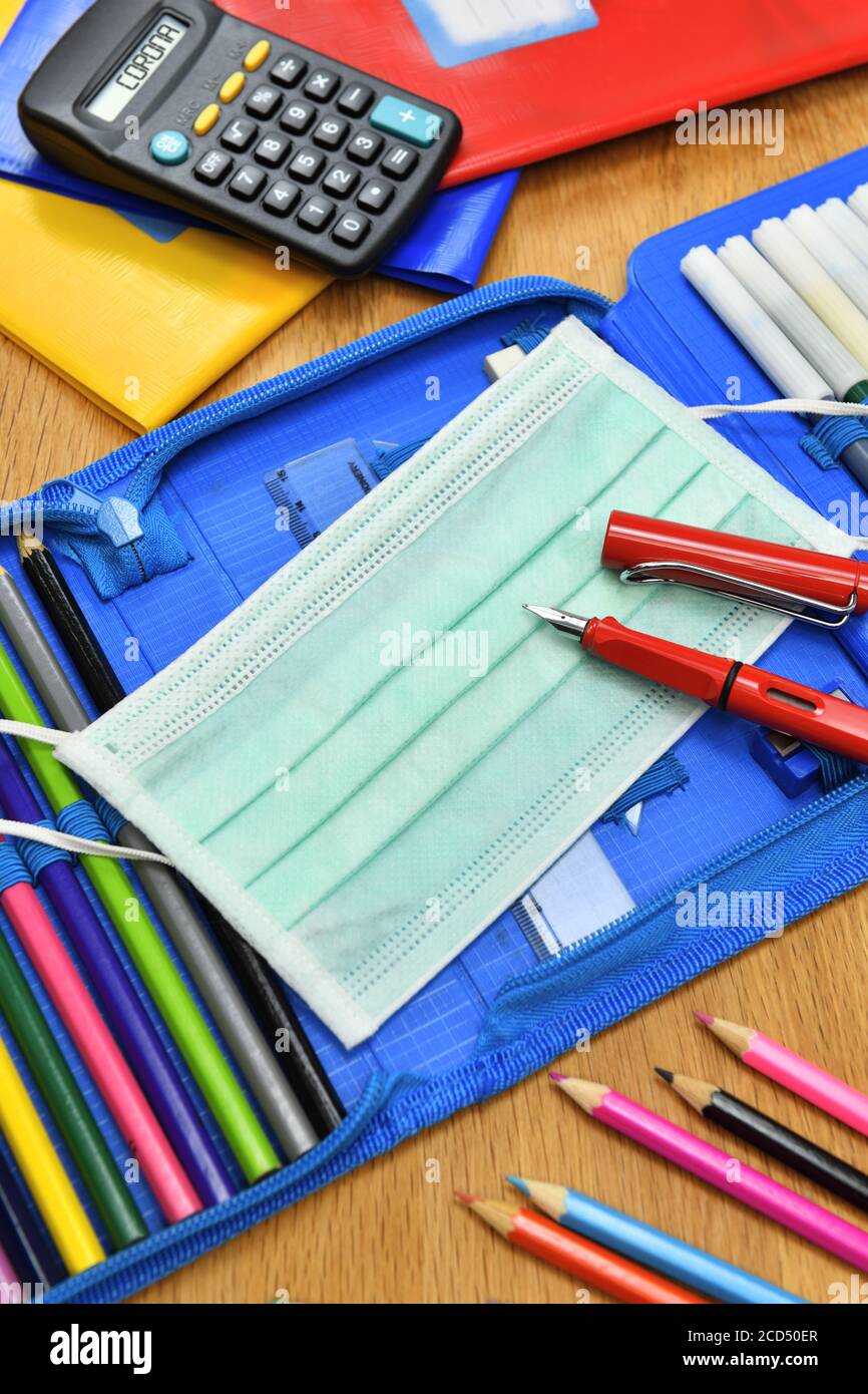 Masque facial Corona et étui à crayons sur le bureau de l'école Banque D'Images