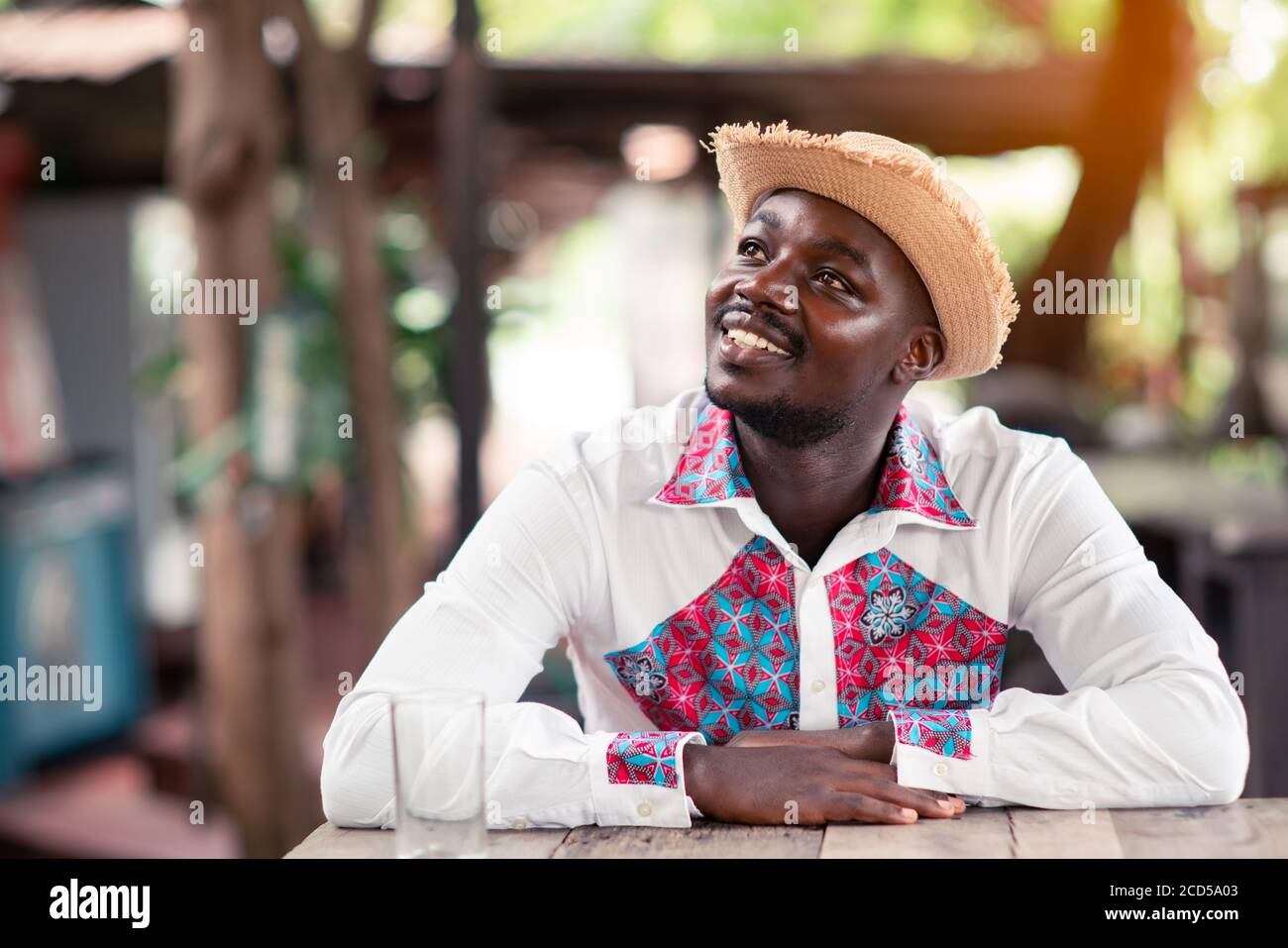 Homme africain portant un chapeau et un tissu indigène traditionnel coloré  avec penser Photo Stock - Alamy