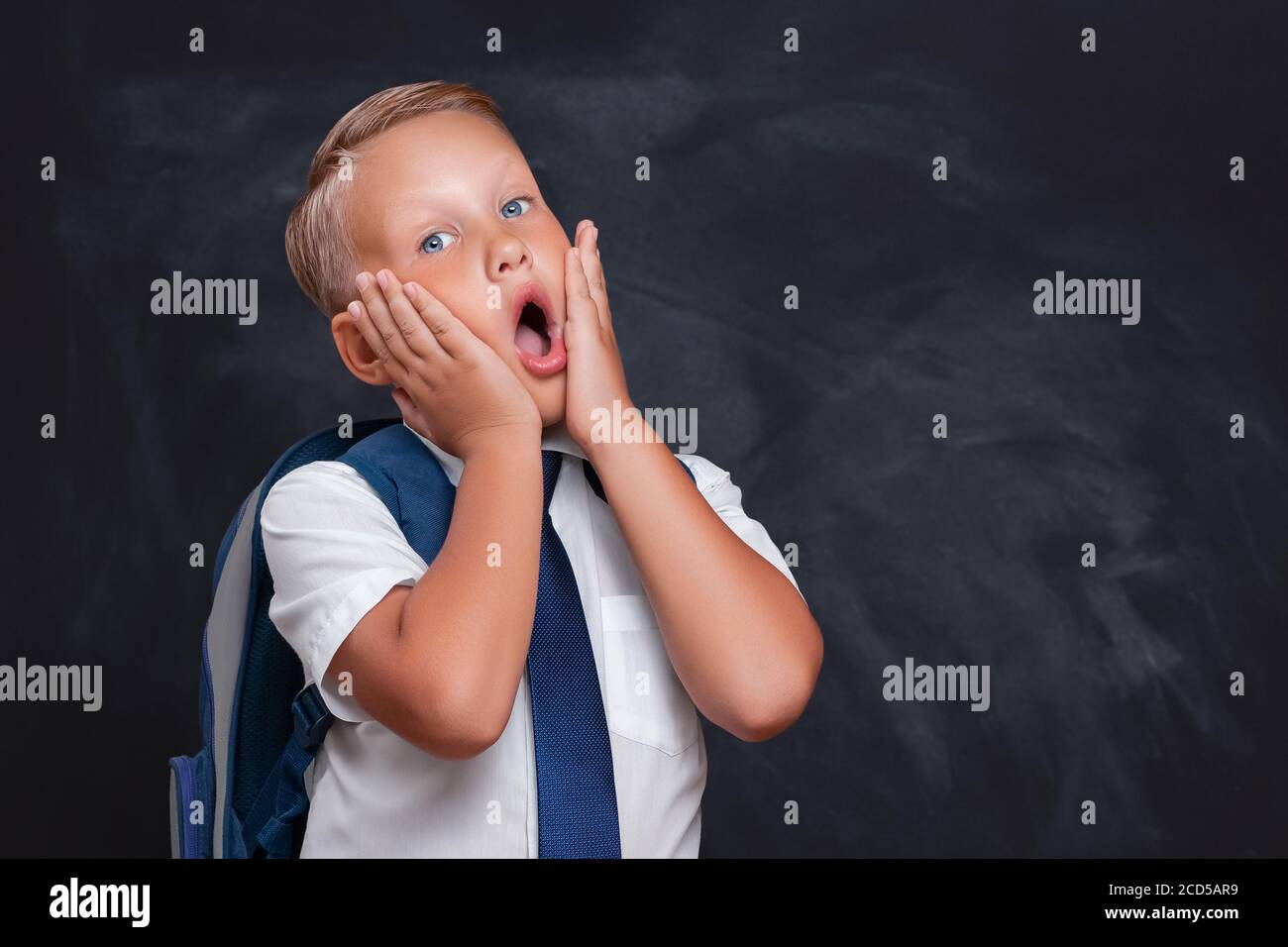 Concept de retour à l'école avec un écolier effrayé en classe Banque D'Images