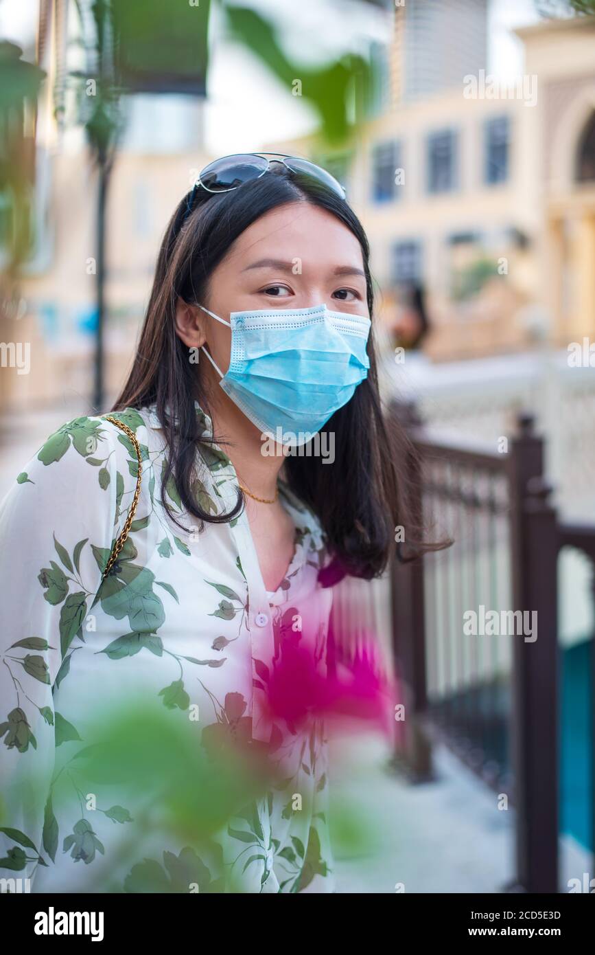 Femme asiatique portant un masque chirurgical à l'extérieur d'un centre commercial à Dubaï. Voyage et loisirs nouvelle norme après la pandémie de coronavirus Covid-19 Banque D'Images