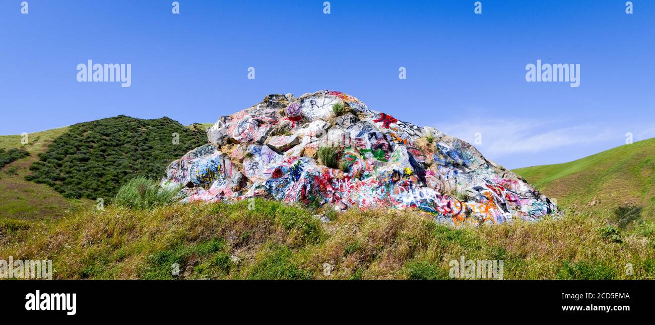 Paysage avec formation de roche vandalisé avec graffiti et collines ondoyantes Banque D'Images