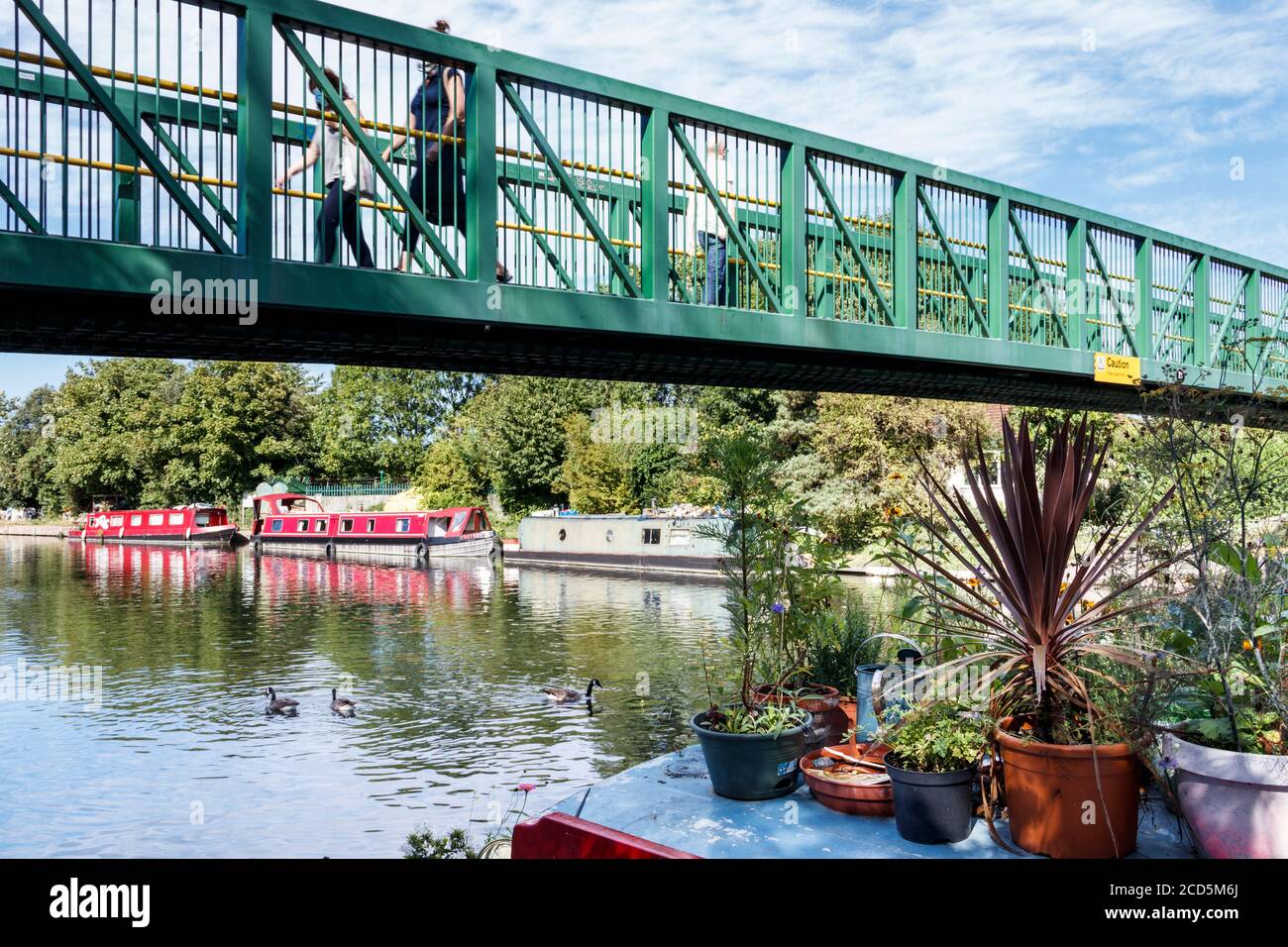 Piétons traversant le pont au-dessus de la rivière Lea par Springfield Park, Clapton, Londres, Royaume-Uni Banque D'Images