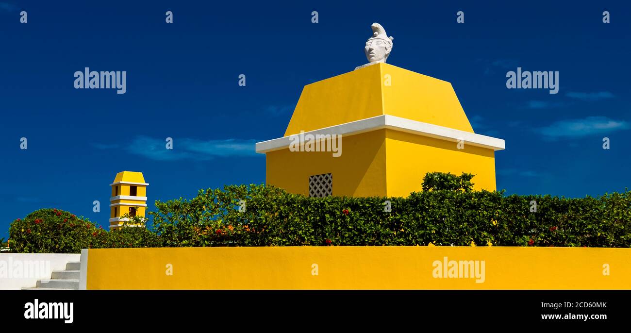 Extérieur de bâtiment jaune avec statue sur le dessus, Mahahual, Quintana Roo, Mexique Banque D'Images