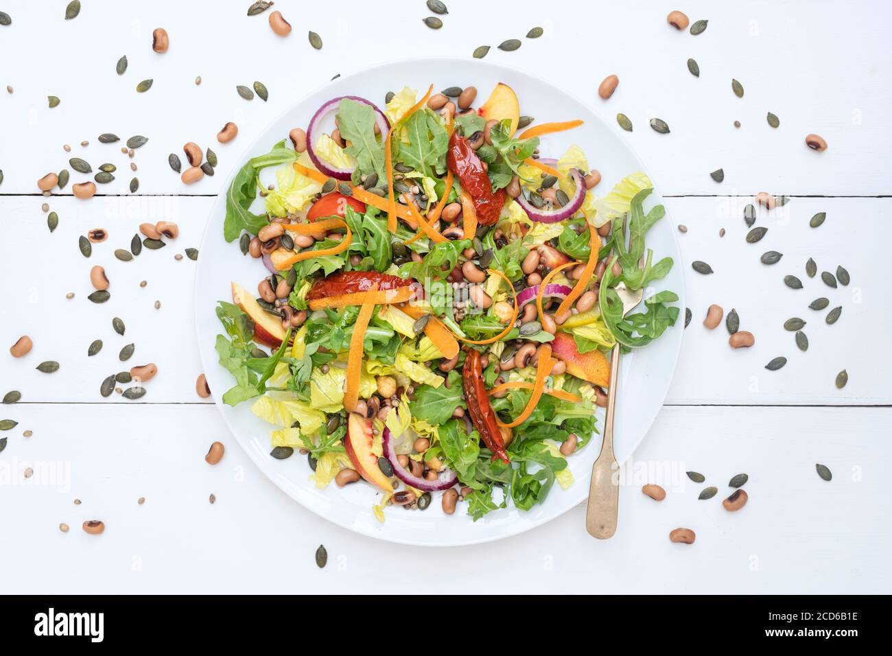 Végétalien. Assiette de salade de haricots, de graines, de noix et de roquette Banque D'Images