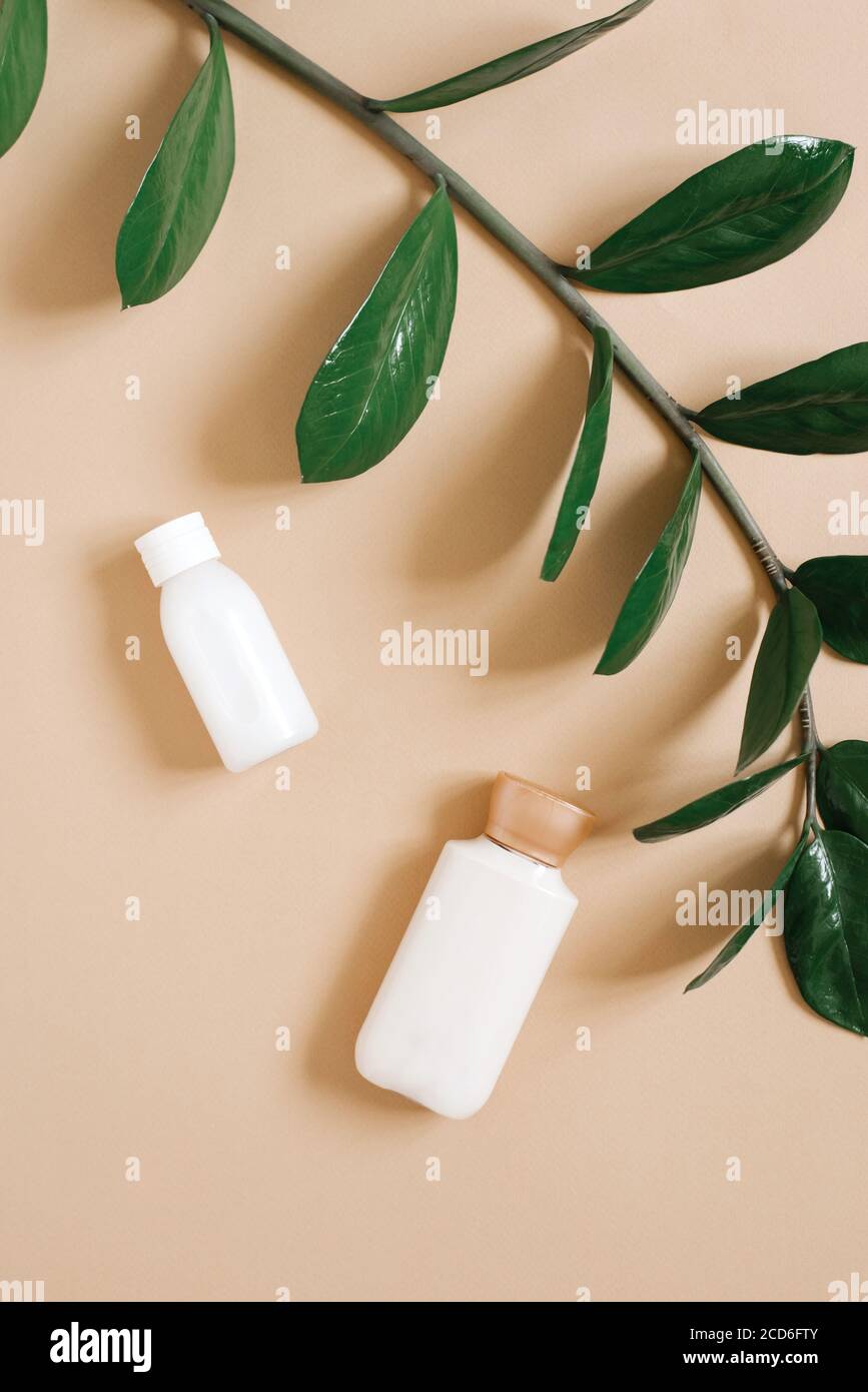 Bouteilles cosmétiques sur fond beige, vue du dessus. Crème pour le corps, gel douche. Produits de spa. Disposition de la bouteille. Banque D'Images