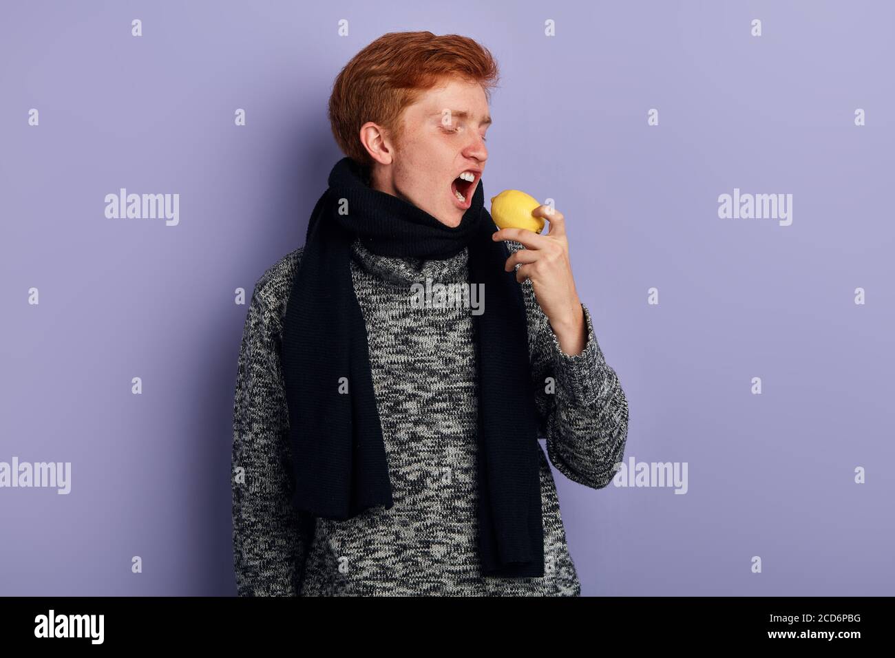 drôle d'homme avec une large bouche ouverte allant au goût citron. gros plan vue de côté photo. traitement efficace utile, prise en studio Banque D'Images