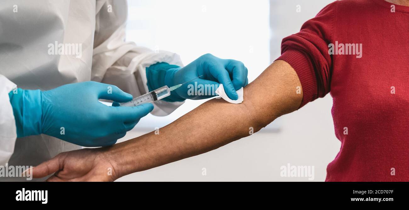 Médecin qui fait un vaccin à seringue par injection médicale à un patient âgé à l'hôpital pour prévenir et arrêter l'éclosion du virus corona Banque D'Images