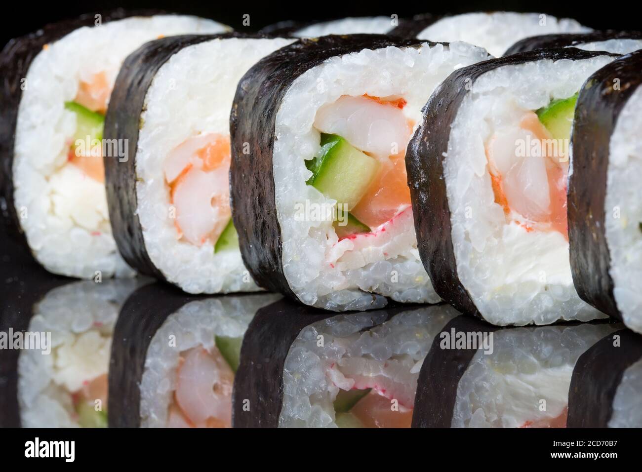Les sushis roulent le Futo Maki sur fond noir. Banque D'Images