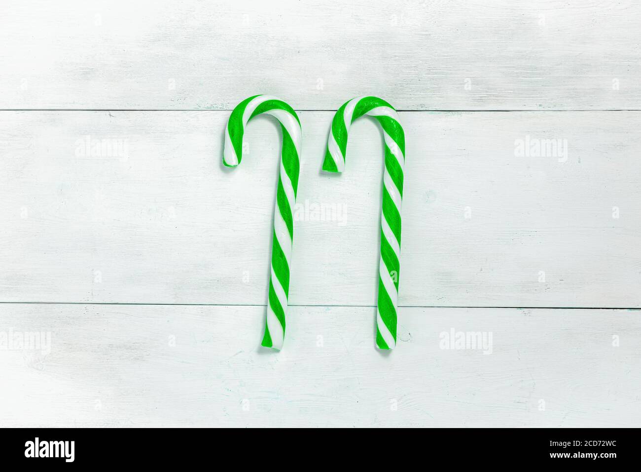2 bonbons de noël de couleur verte sur une lumière arrière-plan en bois Banque D'Images