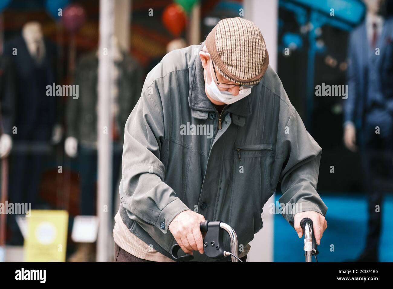 Homme âgé au centre-ville de Preston avec masque facial et marcheur qui se rend dans la ville. Banque D'Images
