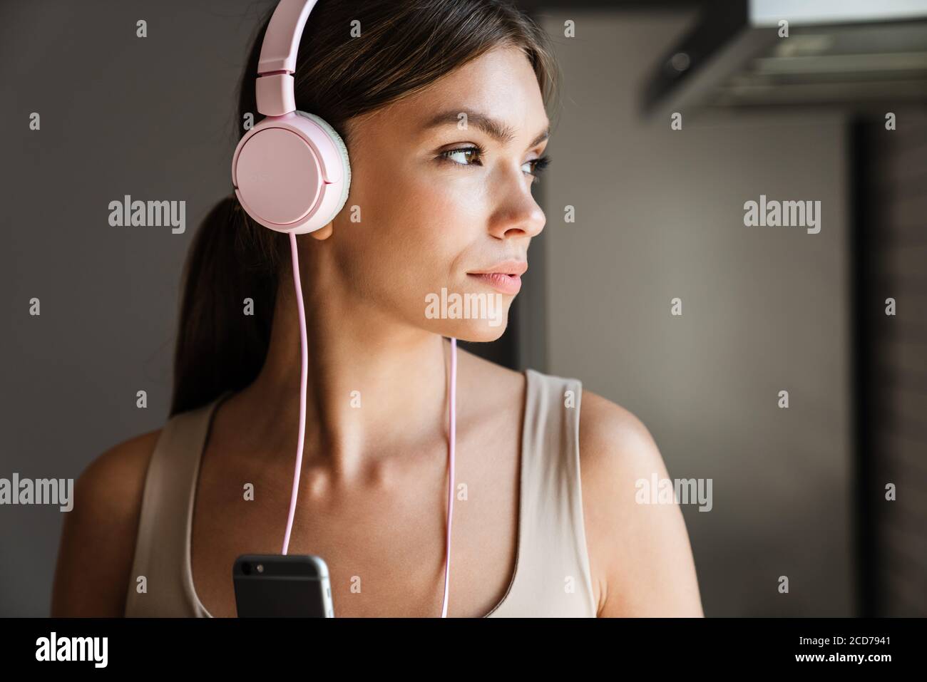 Belle jeune femme avec casque pour écouter de la musique à la maison Banque D'Images