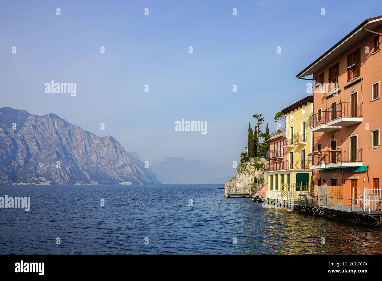 Maisons colorées à Malcesine sur la rive du lac de Garde avec des montagnes en arrière-plan Banque D'Images