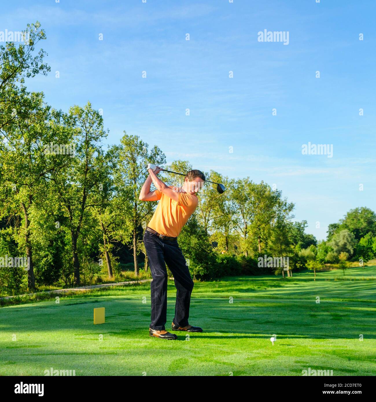 Jeune homme jouant au golf par beau temps Banque D'Images