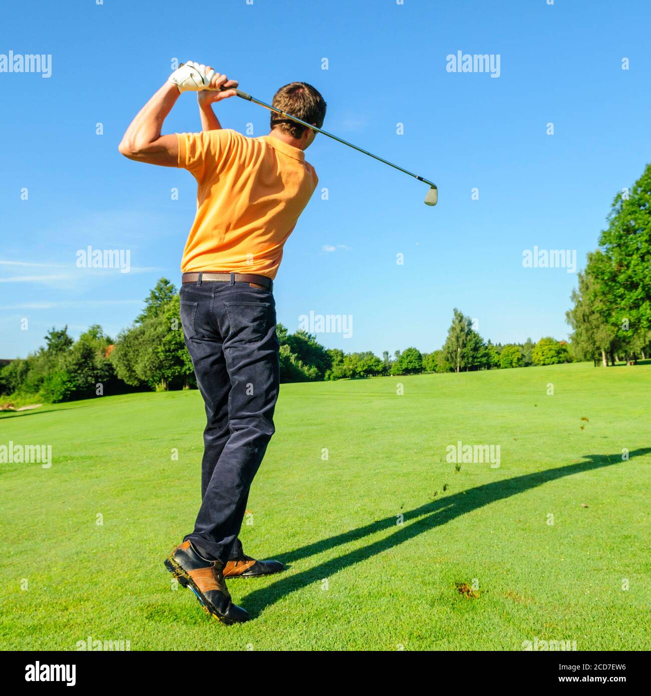 Jeune homme jouant au golf par beau temps Banque D'Images