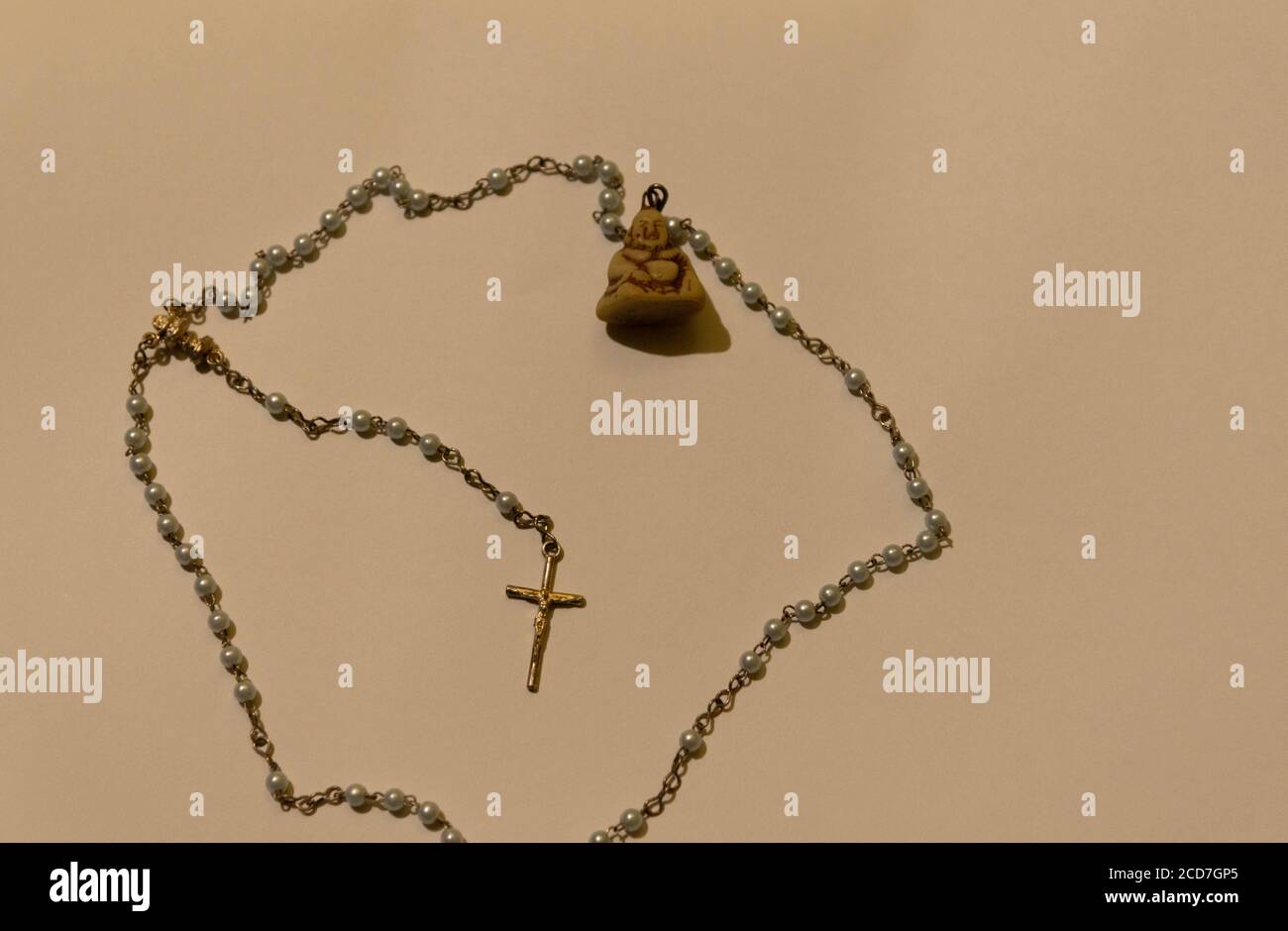 L'image d'un rosaire ou tiers catholique et un pendentif crucifix à son extrémité et un autre du bouddhisme. Artefact religieux des Catholiques et Bouddhistes fai Banque D'Images