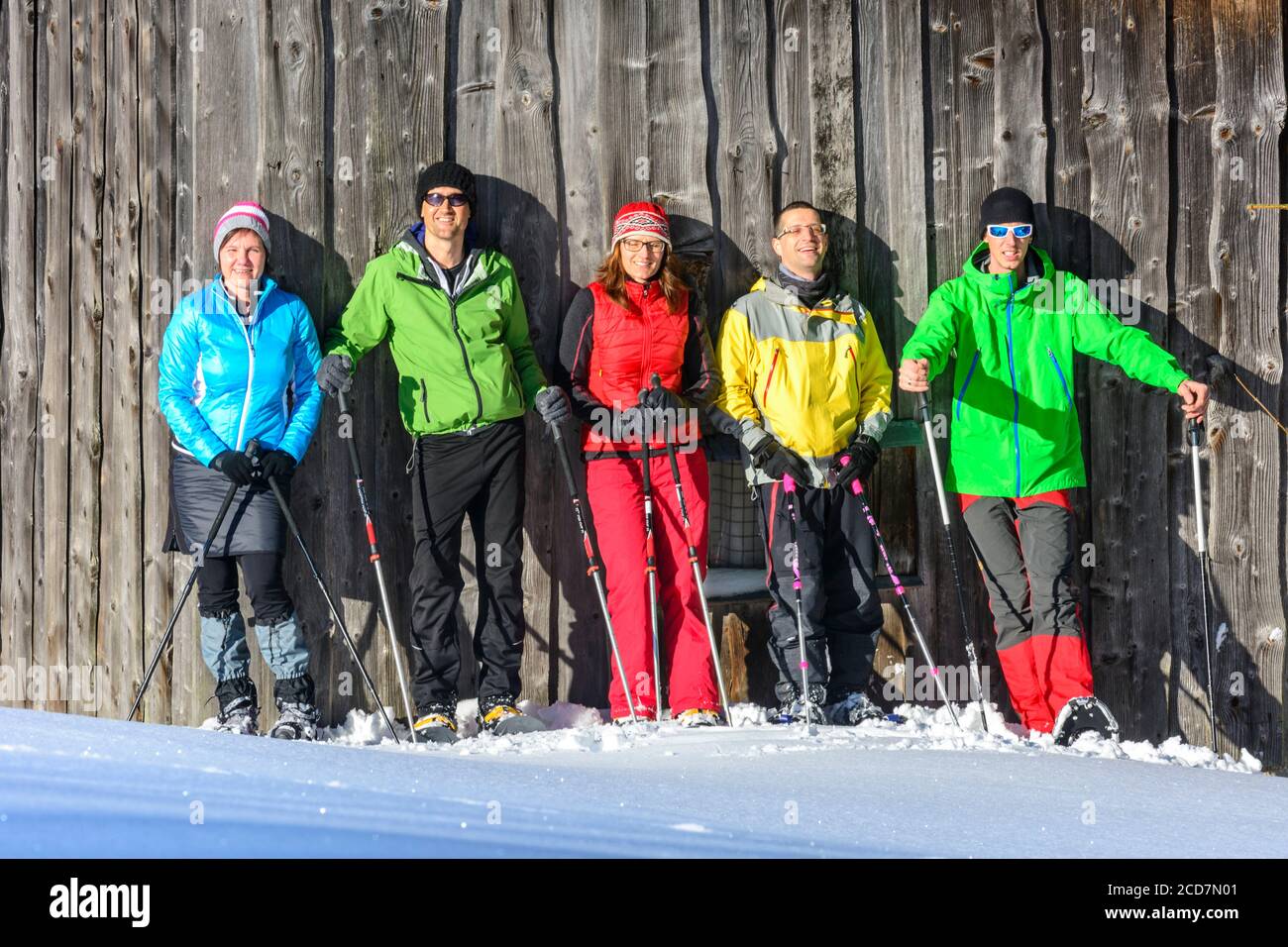 Un groupe de bonne humeur des gens qui font un tour en raquettes à la nature à un hiver froid et ensoleillé jour Banque D'Images