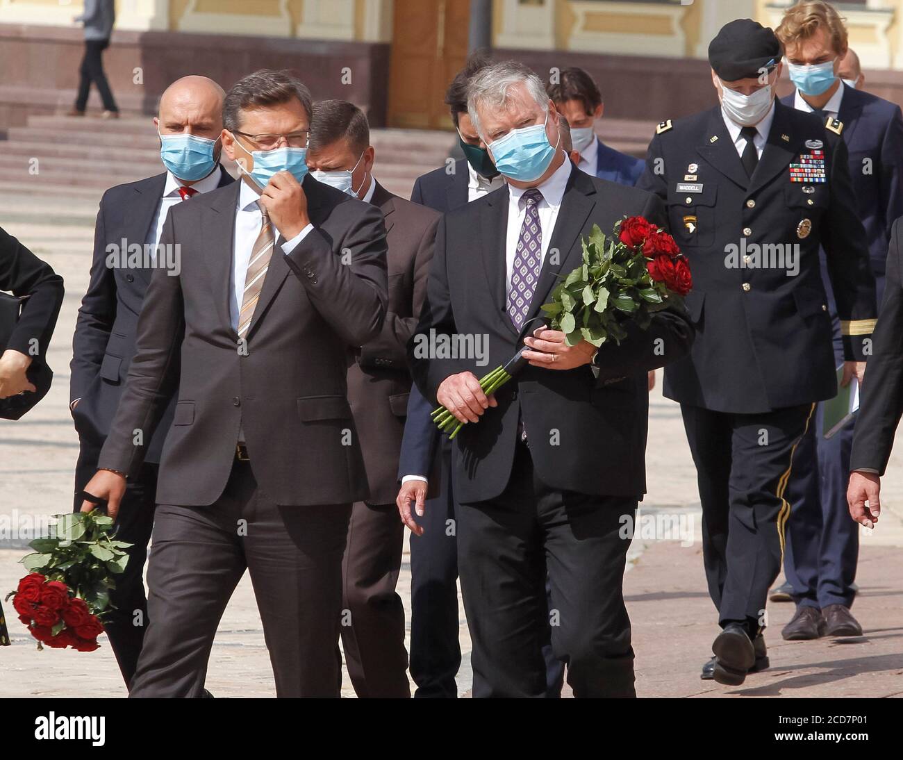 Kiev, Ukraine. 27 août 2020. LE secrétaire d'État ADJOINT AMÉRICAIN Stephen Biegun (C) et le ministre ukrainien des Affaires étrangères Dmytro Kuleba (L) portant des masques faciaux participent à une cérémonie de pose de fleurs sur le mur commémoratif des militaires ukrainiens tués dans le conflit de guerre dans l'est du pays. Stephen Biegun, secrétaire d'État adjoint, se trouve à Vilnius, en Lituanie, à Moscou, en Russie, à Kiev, en Ukraine, du 24 au 27 août 2020, pour rencontrer des hauts dirigeants du gouvernement afin de discuter d'une gamme de questions régionales et internationales, a informé le département d'État des États-Unis. Crédit : SOPA Images Limited/Alamy Live News Banque D'Images