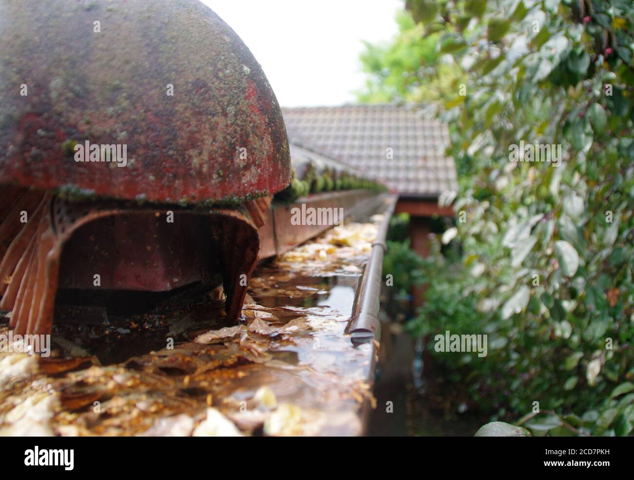 De l'eau dans un toit bouché coule après la pluie. Problèmes de rétention d'eau de pluie. Banque D'Images