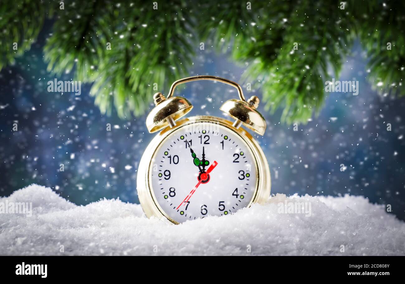 Arrière-plan de Noël ou du nouvel an avec réveil Golden les chutes de neige sur fond bleu et les lumières des fêtes comptent sur les derniers moments Avant la messe de Noël Banque D'Images