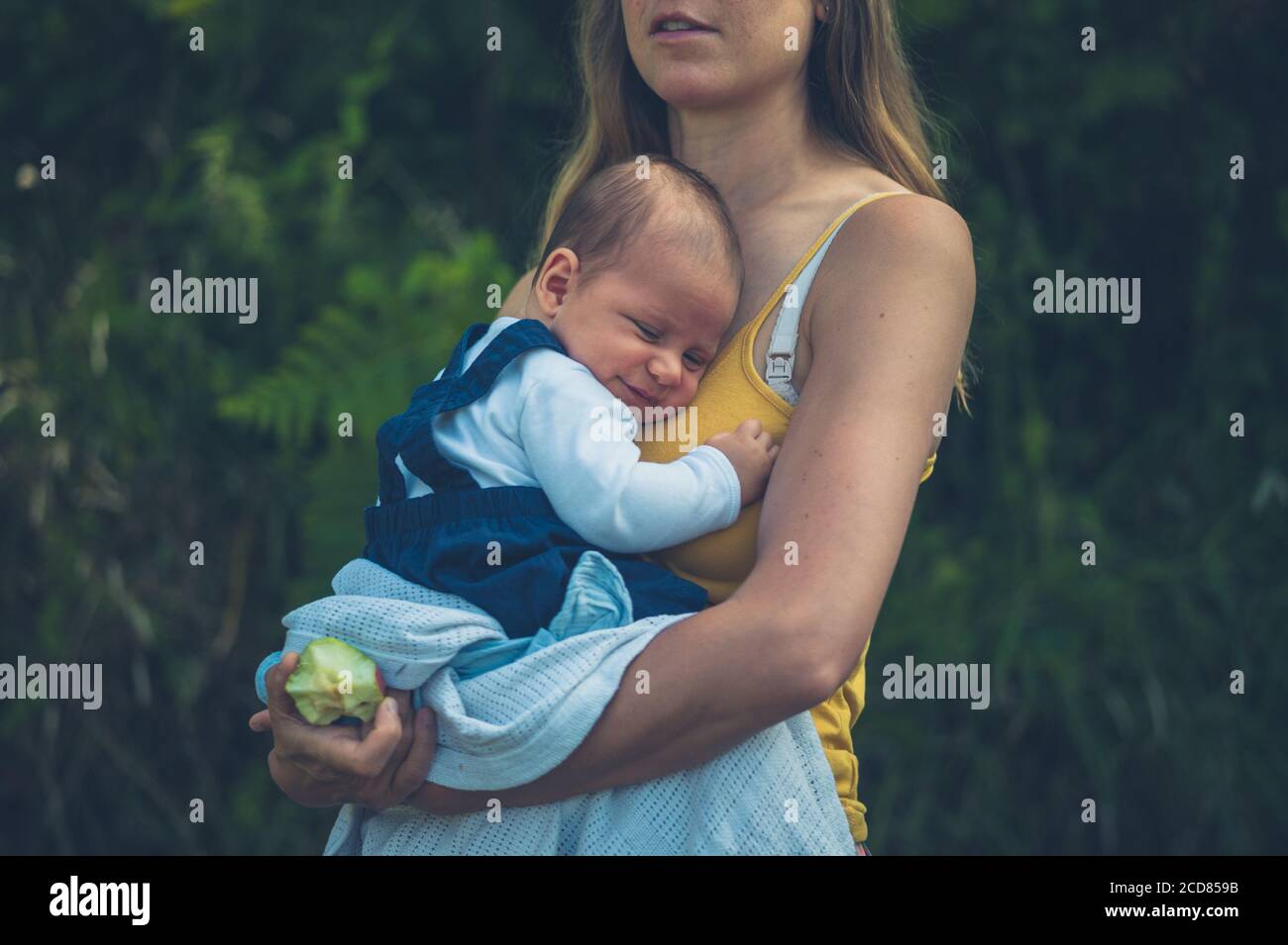Une jeune mère est debout dans le jardin avec elle bébé Banque D'Images