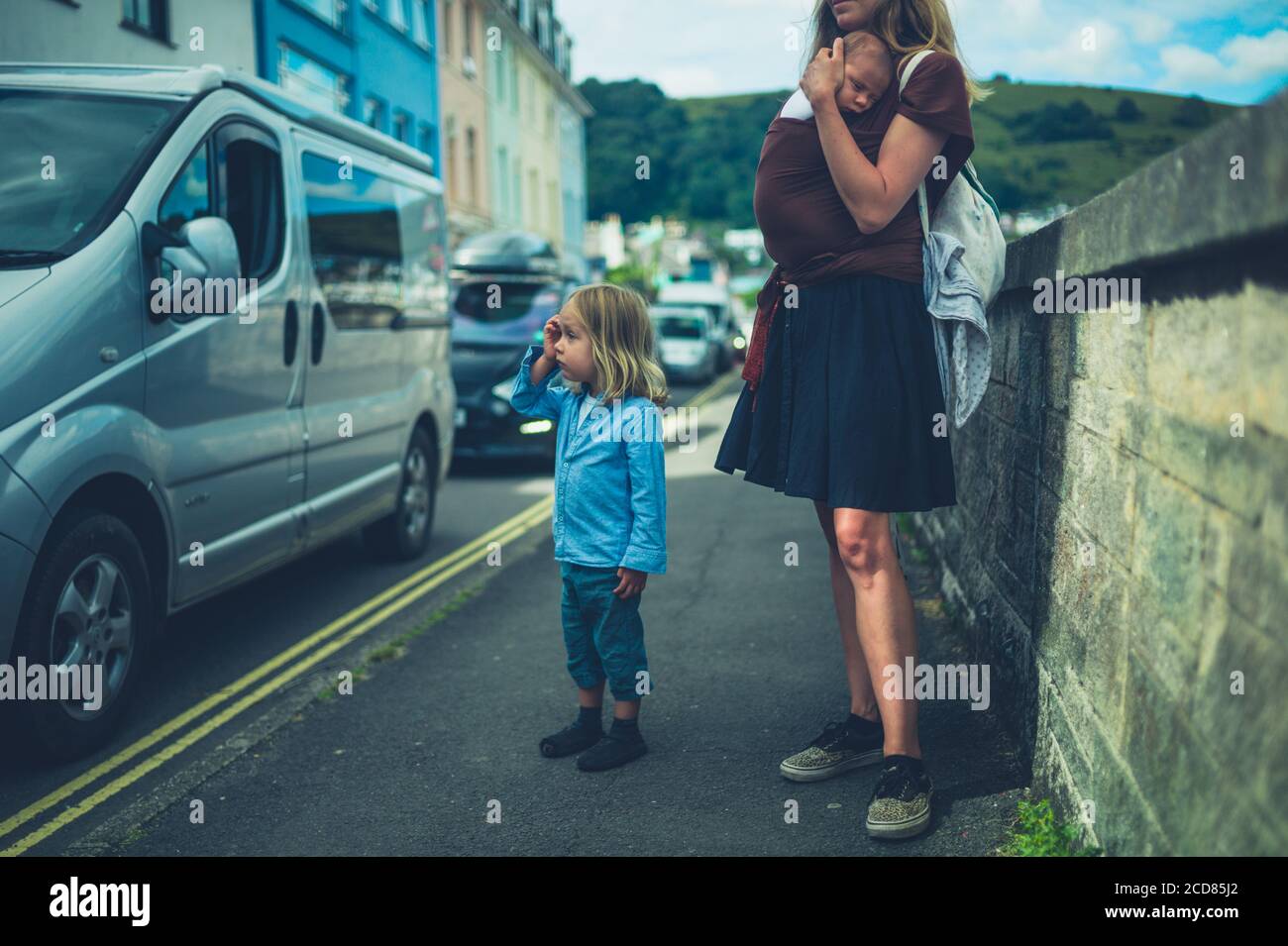 Une jeune mère est debout dans la rue avec elle bébé et préchoeur Banque D'Images