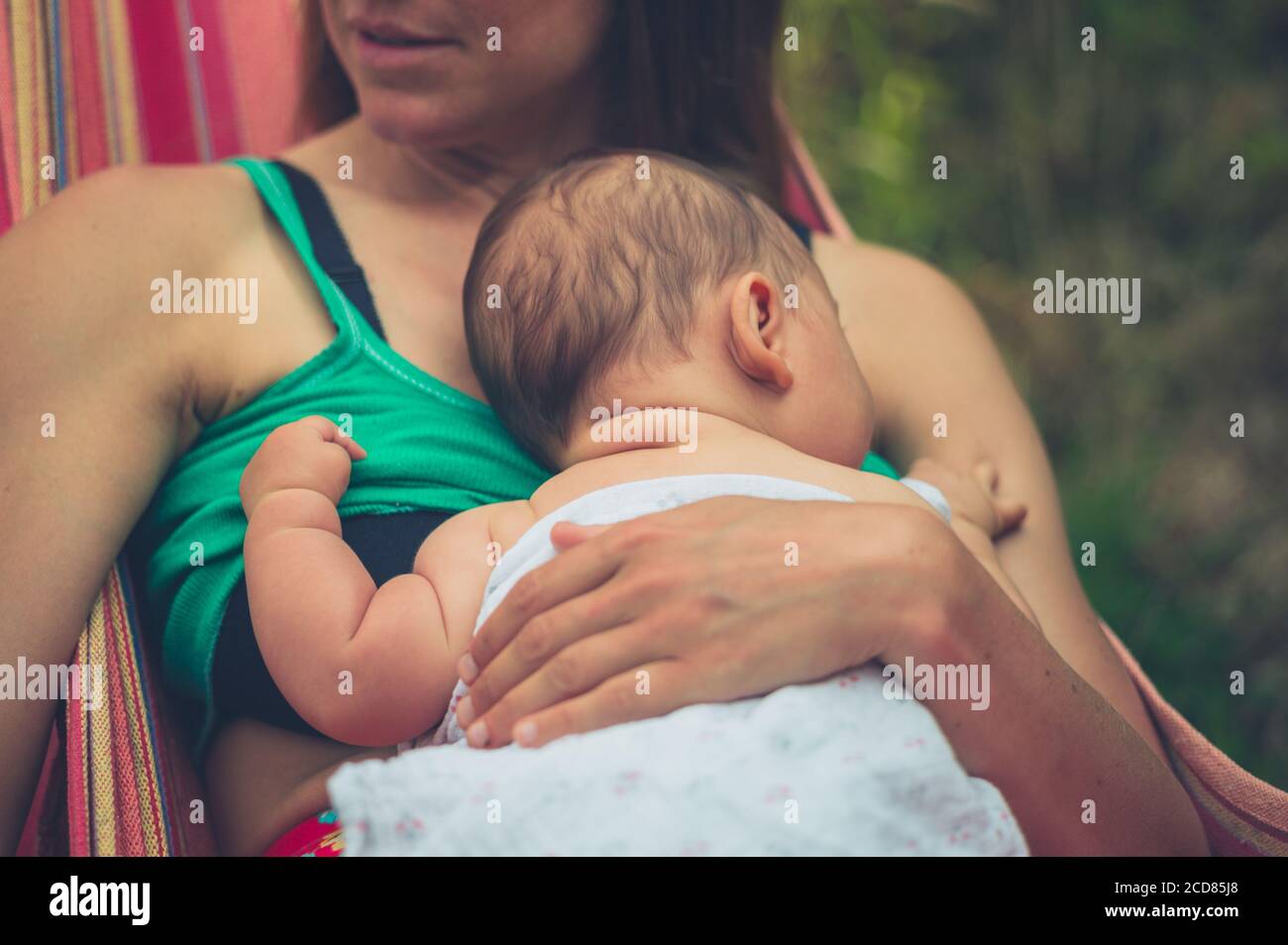 Une jeune mère se repose dans un hamac avec elle bébé en été Banque D'Images