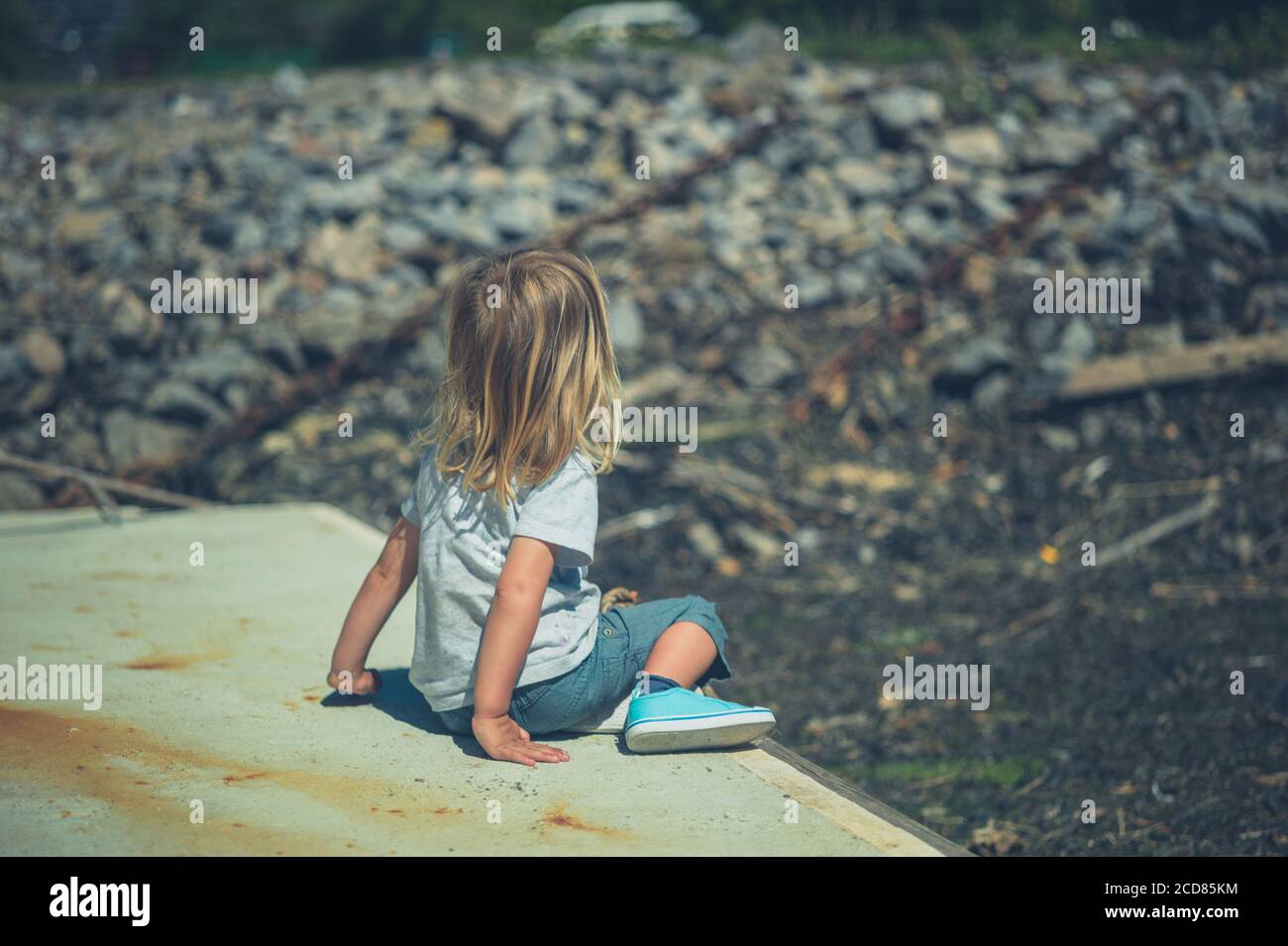 Un petit préchooler joue à l'extérieur au soleil Banque D'Images