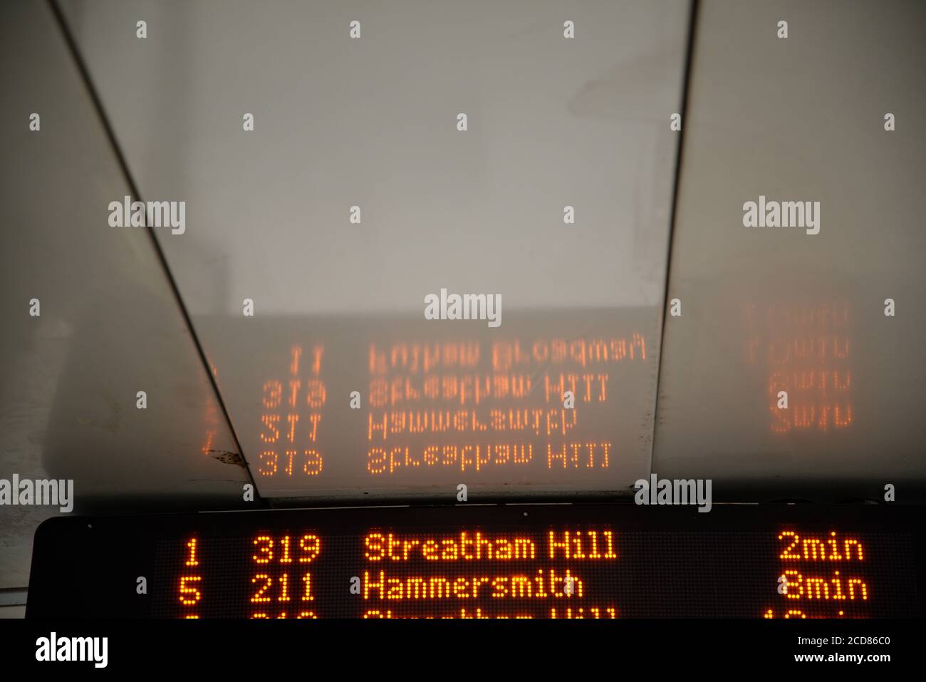Image abstraite de la réflexion sur le plafond d'un abri d'autobus à Londres. Affichage des heures d'arrivée du bus. Espace pour le texte. Banque D'Images