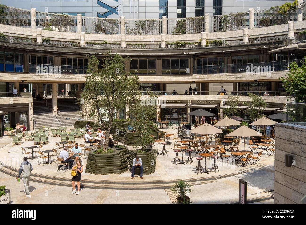 Les employés de bureau apprécient leur pause déjeuner sur un mot ensoleillé au Broadgate Circle. Londres Banque D'Images