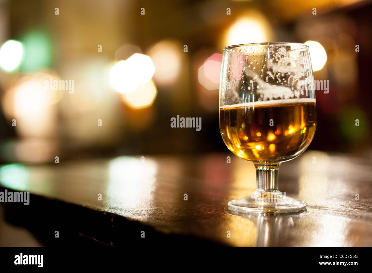 Un verre de bière à moitié bu est assis sur une table Rétroéclairage supérieur par la lumière du soir dans une rue extérieure.bokeh dedans Contexte.Séville.Espagne Banque D'Images