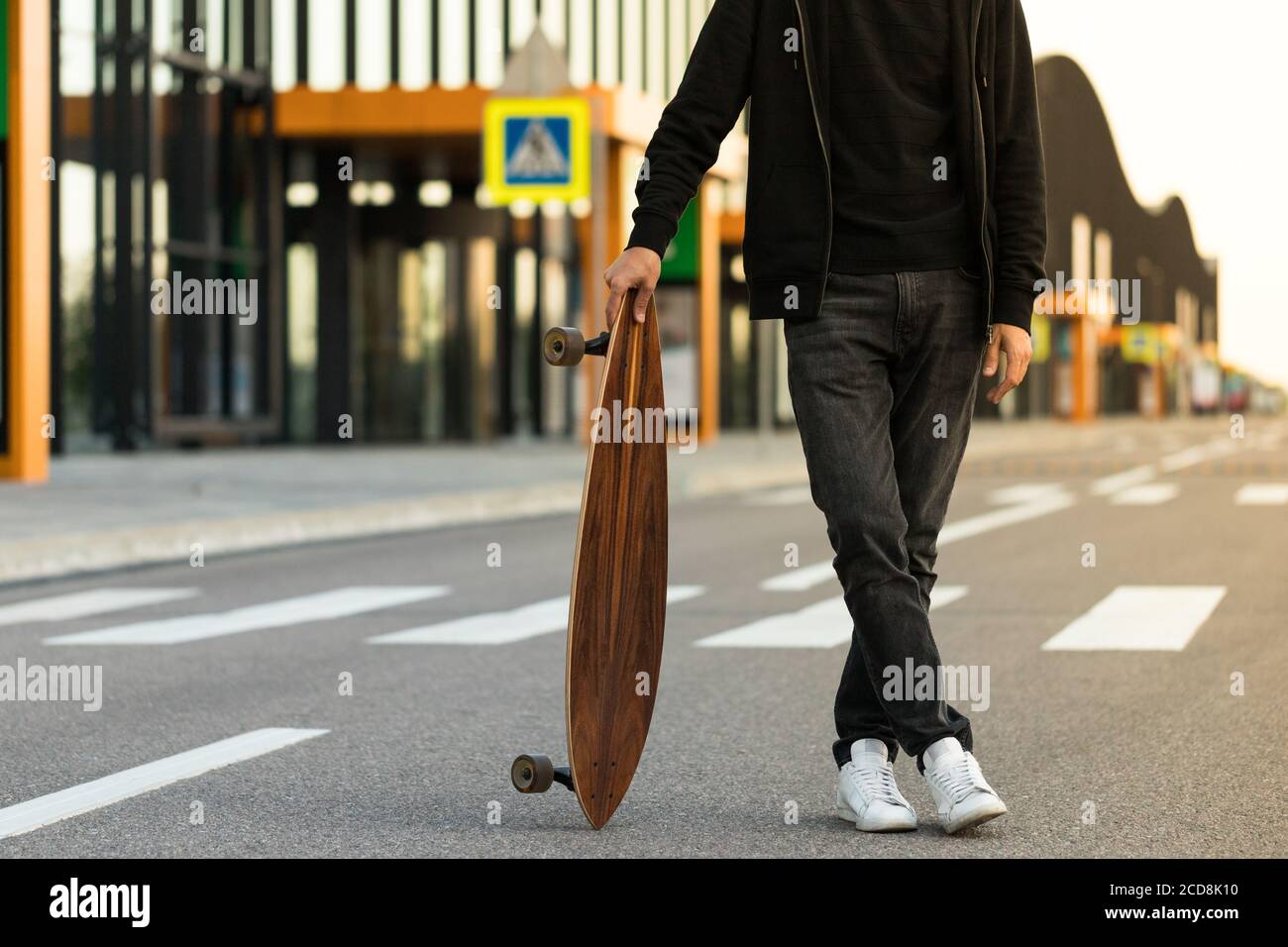 Boxer homme debout avec planche à roulettes ou planche à repasser en plein air, image rognée. Loisirs, mode de vie sain, sports extrêmes Banque D'Images