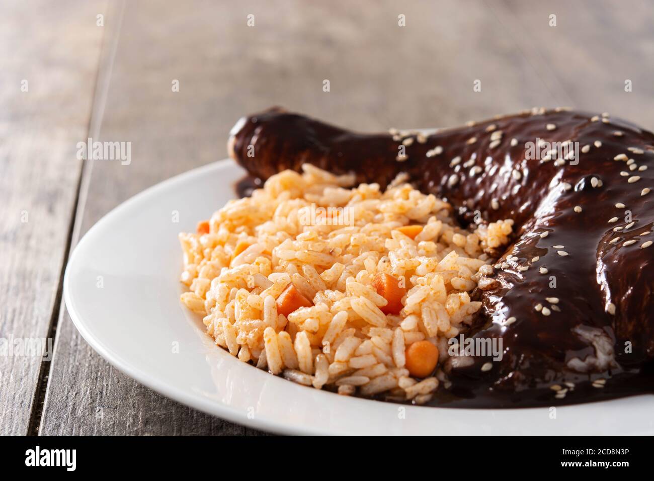 Mole traditionnelle Poblano avec riz dans une assiette sur une table en bois Banque D'Images