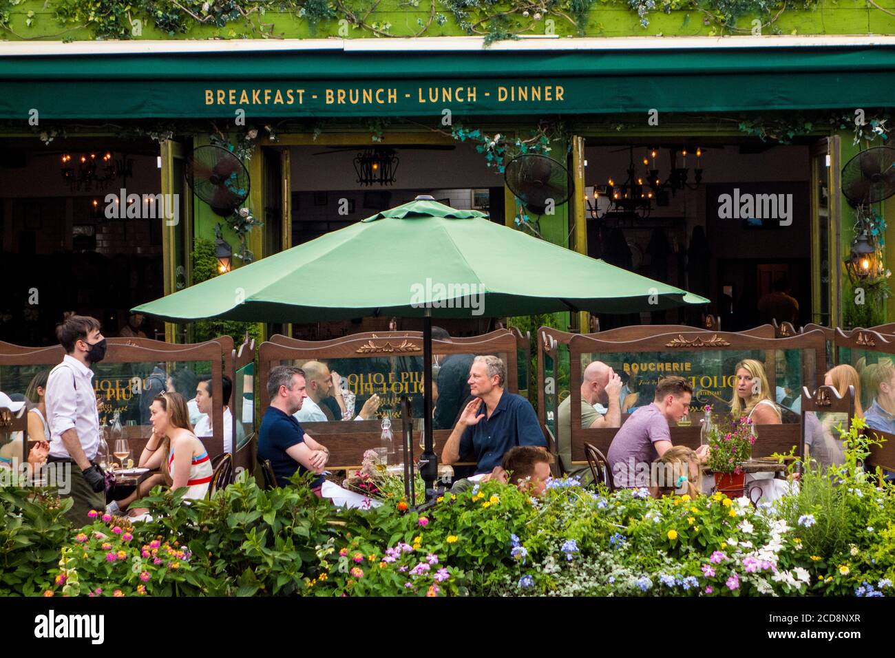 Places en plein air avec plexiglas protecteur pendant la pandémie Covid 19 au restaurant italien Olio e PIU de Greenwich Village, New York City, NY, États-Unis Banque D'Images