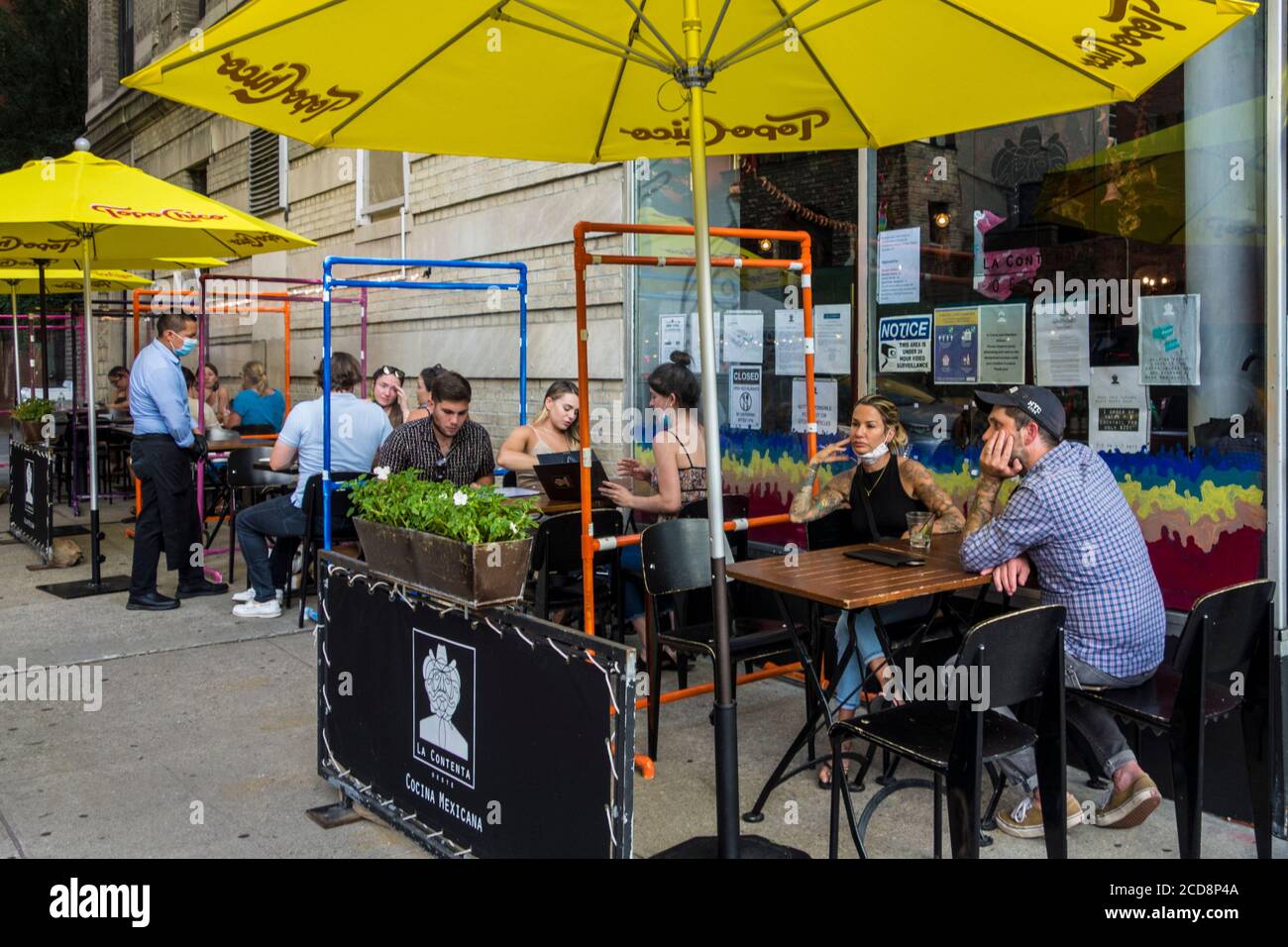 Places en plein air avec écrans protecteurs en plexiglas pendant la pandémie Covid 19 au restaurant mexicain la Cocina Oeste, New York City, NY, USA Banque D'Images