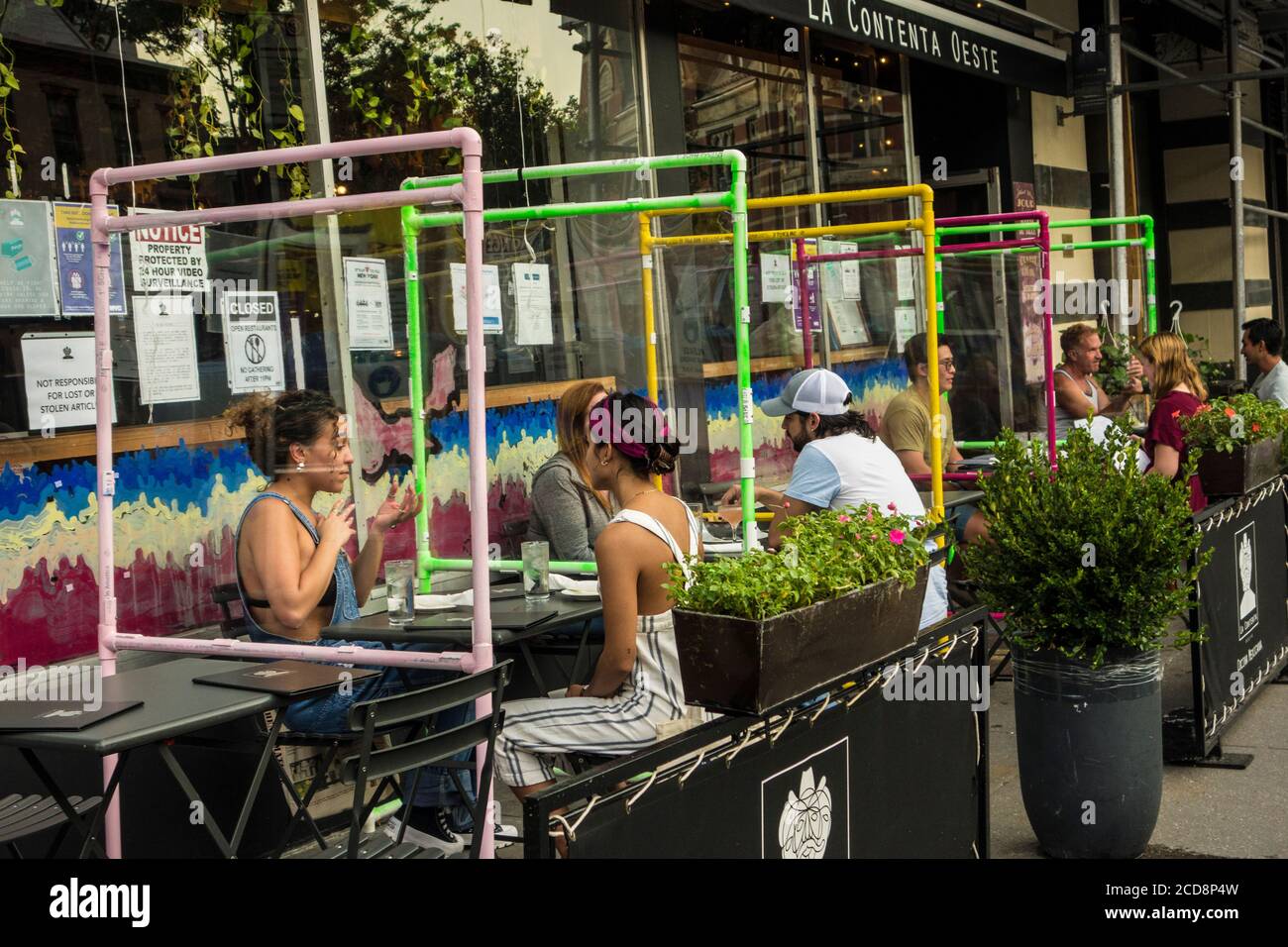 Places en plein air avec écrans protecteurs en plexiglas pendant la pandémie Covid 19 au restaurant mexicain la Cocina Oeste, New York City, NY, USA Banque D'Images