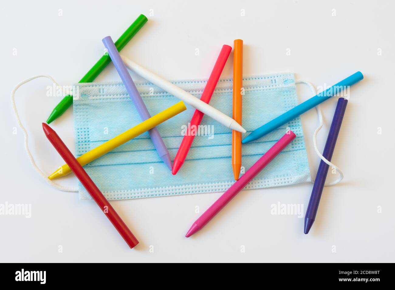 Anti virus masque sur certains crayons de couleur d'école. Concept de retour à l'école dans la nouvelle norme. Banque D'Images