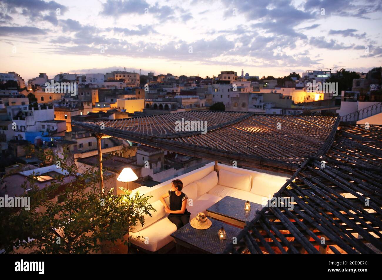 Maroc, région de Tanger Tétouan, Tanger, hôtel Dar Nour, femme sur la terrasse de la maison d'hôtes Dar Nour, surplombant la Kasbah, à la tombée de la nuit Banque D'Images