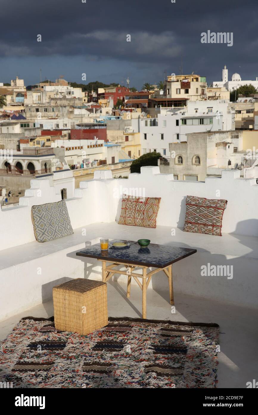 Maroc, région de Tanger Tétouan, Tanger, hôtel Dar Nour, terrasse blanche de la maison d'hôtes Dar Nour, décorée avec des coussins orientaux et une table en zelligue, surplombant la Kasbah Banque D'Images