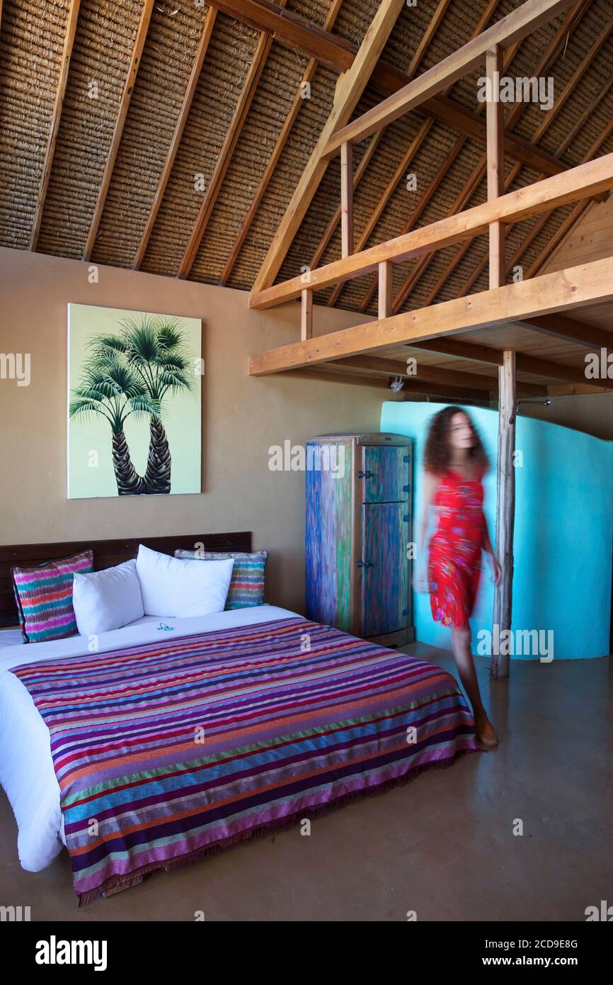 Maroc, Sahara occidental, Dakhla, femme en robe rouge dans une chambre à l'hôtel West point Banque D'Images