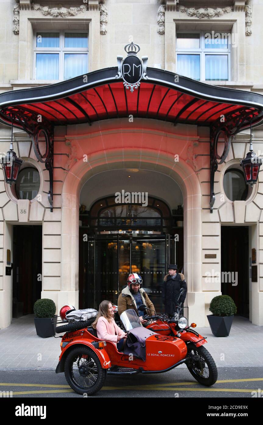 France, Paris, Hôtel Royal Monceau, femme à bord d'une voiture rétro devant la façade de l'hôtel gardée par deux valets Banque D'Images